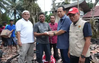 Bupati Muarojambi, Bambang Bayu Suseno (kanan) menyerahkan bantuan kepada korban kebakaran di Desa Sebapo, Kabupaten Muarojambi, Provinsi Jambi || Dok
