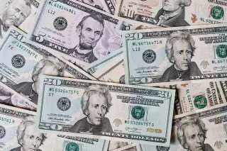 Ilustrasi: Tumpukan uang kertas dolar Amerika Serikat berbagai pecahan dari sudut atas.