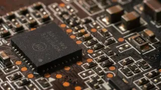 Ilustrasi: Foto makro komponen cip mikroprosesor dan sirkuit elektronik pada papan sirkuit cetak.