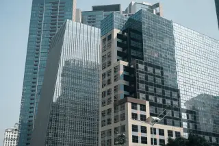 Ilustrasi: Deretan gedung pencakar langit modern berlapis kaca di kawasan perkotaan.