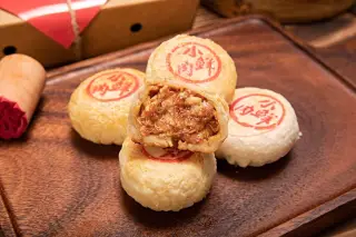 Ilustrasi: Beberapa kue bulan tradisional berisi daging disajikan di atas talenan kayu.