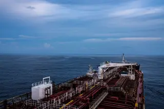 Ilustrasi: Dek kapal tanker minyak yang sedang berlayar di laut lepas di bawah langit berawan.