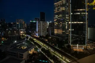 Ilustrasi: Pemandangan malam deretan gedung bertingkat dan jalur kereta layang dari ketinggian.