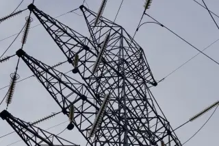 Ilustrasi: Menara transmisi listrik baja dengan kabel berlatar langit berawan.