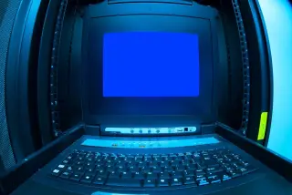 Ilustrasi: Konsol terminal server dengan layar biru dan papan ketik di dalam rak data center.