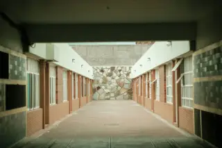 Ilustrasi: Lorong luar ruangan yang sepi diapit bangunan berpintu dan jendela.