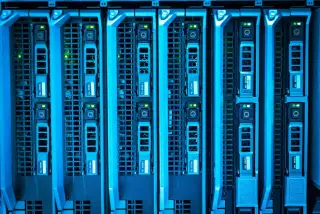 Ilustrasi: Deretan unit server penyimpanan data dengan lampu indikator hijau dan pencahayaan biru.