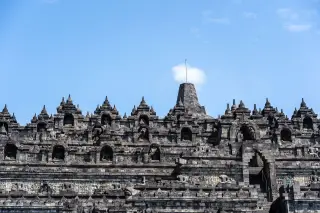 Ilustrasi: Struktur bertingkat Candi Borobudur dengan latar langit biru cerah.