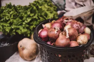Ilustrasi: Bawang merah di dalam keranjang hitam bersanding dengan selada hijau segar.