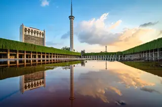 Ilustrasi: Menara Masjid Istiqlal dan Monas terpantul di kolam air saat langit senja.