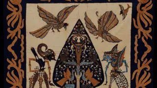 Ilustrasi: Kain batik bermotif wayang kulit, gunungan, dan burung dengan bingkai ornamen tradisional.