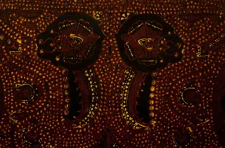 Ilustrasi: Foto jarak dekat permukaan kain batik dengan motif tradisional berwarna cokelat gelap.