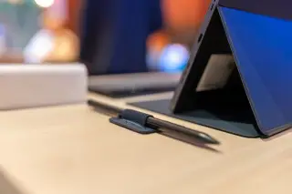Ilustrasi: Sebuah tablet tersangga dengan pena digital di sampingnya di atas meja kayu.