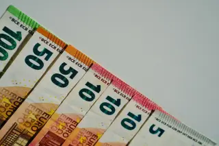 Ilustrasi: Deretan uang kertas euro berbagai pecahan tersusun di atas latar polos.