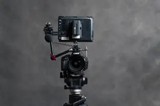 Ilustrasi: Sebuah kamera DSLR terpasang pada tripod lengkap dengan mikrofon dan monitor eksternal.