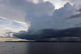 Ilustrasi: Awan cumulonimbus gelap dan pekat membentang di atas perairan terbuka.
