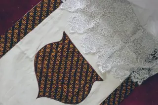 Ilustrasi: Detail kain bermotif batik cokelat dipadukan dengan renda putih.