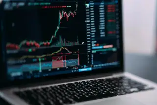 Ilustrasi: Layar laptop menampilkan grafik pergerakan harga saham dan instrumen keuangan.