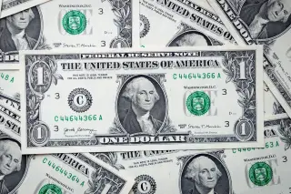 Ilustrasi: Satu lembar uang kertas satu dolar AS terbentang di atas tumpukan uang serupa.