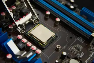 Ilustrasi: Prosesor komputer terpasang pada soket motherboard dengan berbagai komponen elektronik di sekitarnya.