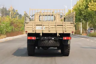 Ilustrasi: Bagian belakang truk militer berwarna krem yang terparkir di jalan aspal.
