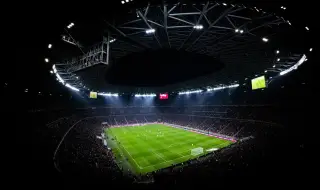 Ilustrasi: Pemandangan dari atas stadion sepak bola megah di malam hari yang dipenuhi penonton.
