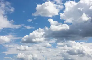 Ilustrasi: Hamparan langit biru berhiaskan gumpalan awan putih dan abu-abu.
