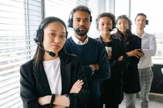 Ilustrasi: Sekelompok pekerja layanan pelanggan mengenakan headset berpose di kantor.