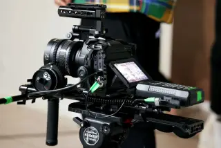 Ilustrasi: Kamera sinema profesional terpasang pada tripod di lokasi syuting.