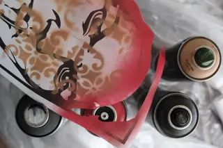 Ilustrasi: Cetakan stensil seni bergambar wajah di dekat beberapa kaleng cat semprot.