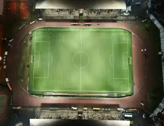 Ilustrasi: Pemandangan udara stadion sepak bola dengan lampu sorot di malam hari.