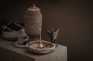 Ilustrasi: Deretan kerajinan tangan berupa kendi tanah liat, anyaman wadah, dan hiasan di atas meja.