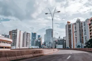 Ilustrasi: Jalan raya perkotaan yang lengang dengan latar belakang deretan gedung bertingkat.
