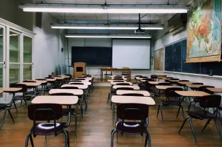 Ilustrasi: Deretan meja dan kursi kosong di dalam sebuah ruang kelas sekolah.