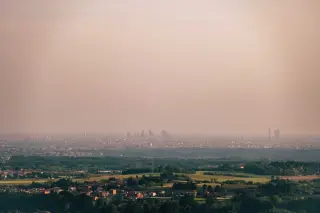 Ilustrasi: Pemandangan lanskap kota dari kejauhan yang tampak tertutup kabut tipis dan polusi udara.