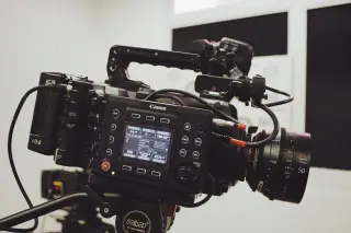 Ilustrasi: Kamera video sinema profesional terpasang pada tripod di dalam ruangan studio.