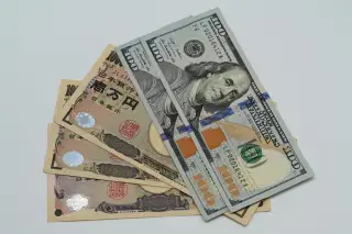 Ilustrasi: Uang kertas seratus dolar Amerika Serikat dan beberapa lembar yen Jepang di atas latar putih.