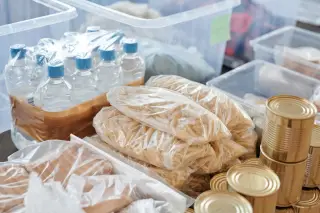 Ilustrasi: Bahan makanan kering, air mineral botol, dan makanan kaleng tertata dalam wadah penyimpanan.