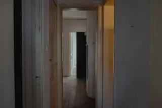 Ilustrasi: Lorong bangunan tua yang kosong dan sunyi dengan pintu-pintu terbuka.