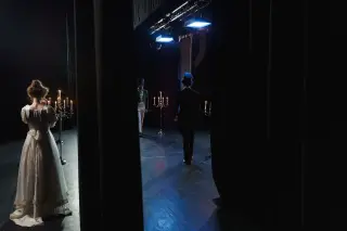 Ilustrasi: Aktor berkostum klasik beraksi di panggung teater dengan tata lampu dan lilin.