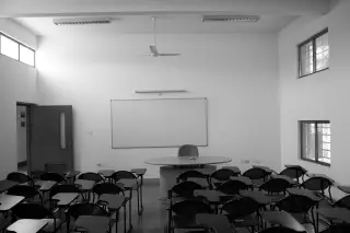 Ilustrasi: Ruang kelas kosong dengan deretan kursi belajar dan papan tulis putih.
