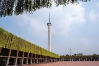 Ilustrasi: Pelataran dan menara Masjid Istiqlal dengan Monas di kejauhan di bawah langit cerah.