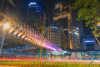Ilustrasi: Pemandangan malam jembatan penyeberangan orang dan gedung-gedung pencakar langit di Jakarta.