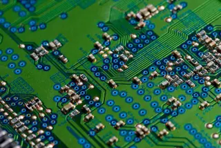 Ilustrasi: Tampilan jarak dekat papan sirkuit elektronik hijau dengan berbagai komponen kecil.
