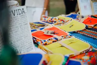 Ilustrasi: Produk kerajinan tangan warna-warni tertata di atas meja bazar luar ruangan.