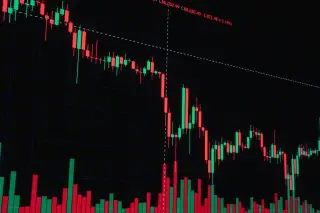 Ilustrasi: Tampilan grafik candlestick pergerakan harga saham berwarna merah dan hijau dengan latar hitam.