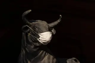 Ilustrasi: Patung banteng berwarna gelap mengenakan masker medis putih dengan latar belakang hitam.