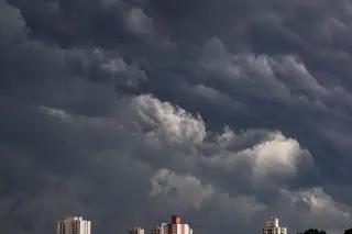 Ilustrasi: Awan mendung tebal dan gelap menyelimuti langit di atas deretan gedung apartemen.