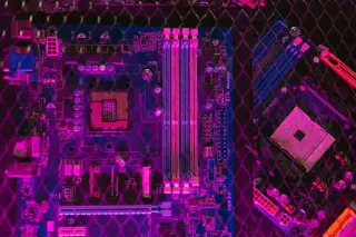 Ilustrasi: Papan sirkuit motherboard komputer dengan pencahayaan warna ungu dan pola jaring kawat.