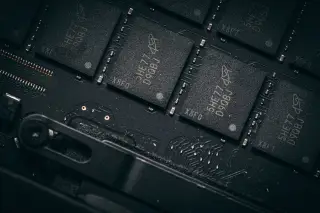 Ilustrasi: Deretan chip memori terpasang pada papan sirkuit elektronik hitam.